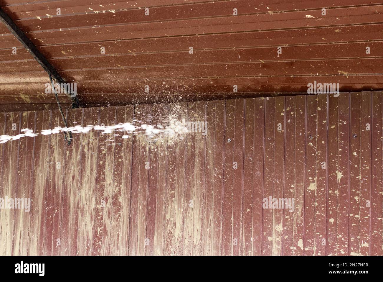 Washing off dirt from fence. Water flow to jet of water. Cleaning