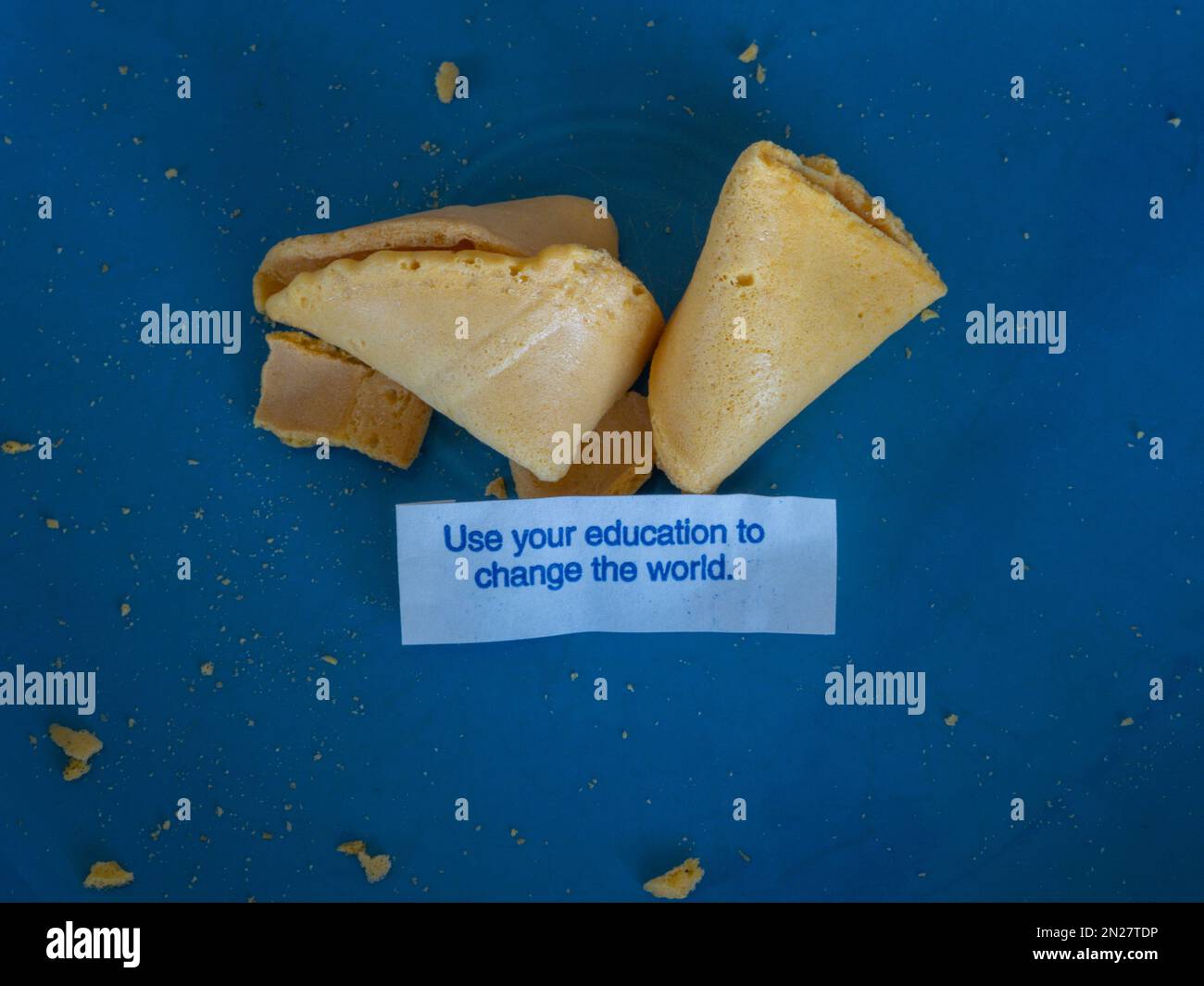 Fortune cookie posits that you use your education to change the world. Stock Photo