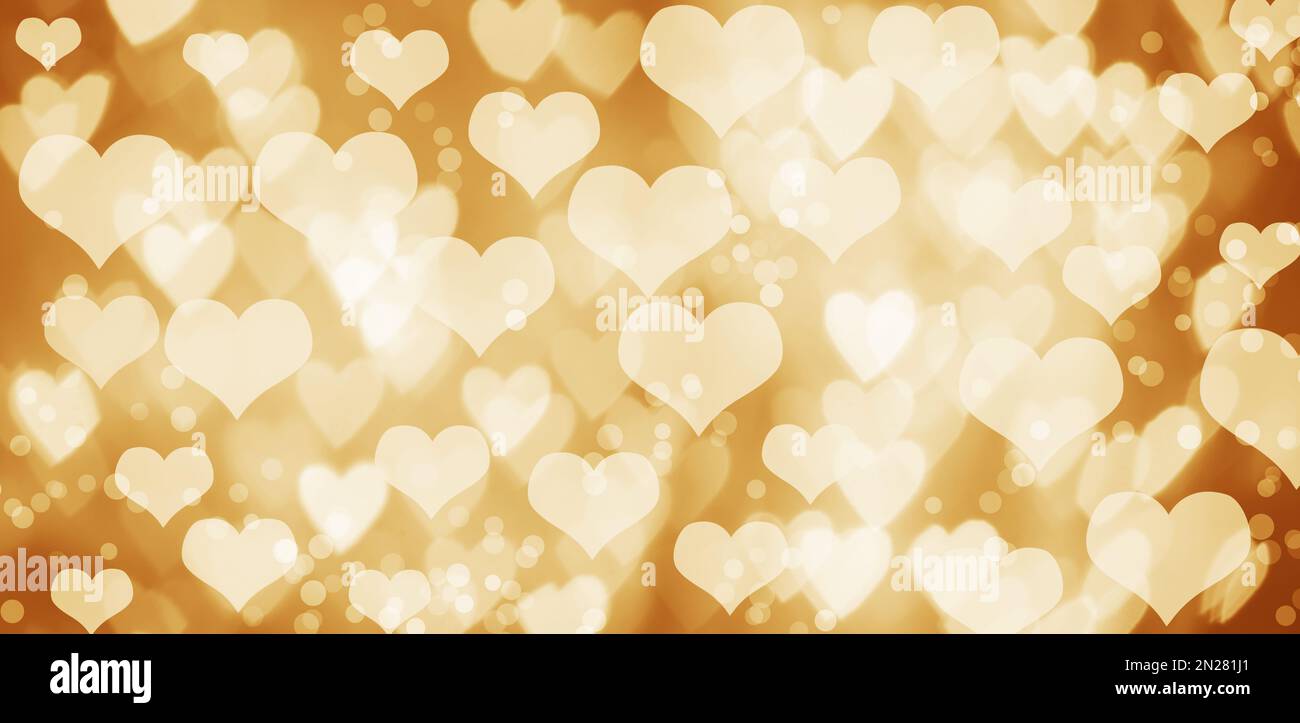 Beautiful hearts and blurred lights on golden background, bokeh effect. Valentine's day Stock Photo
