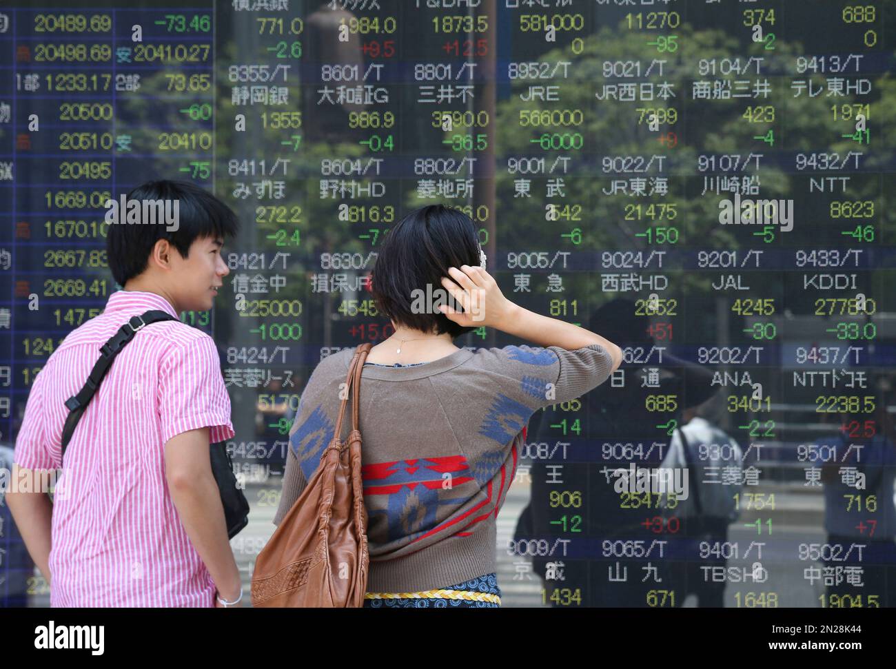 People look at an electronic stock board of a securities firm in Tokyo