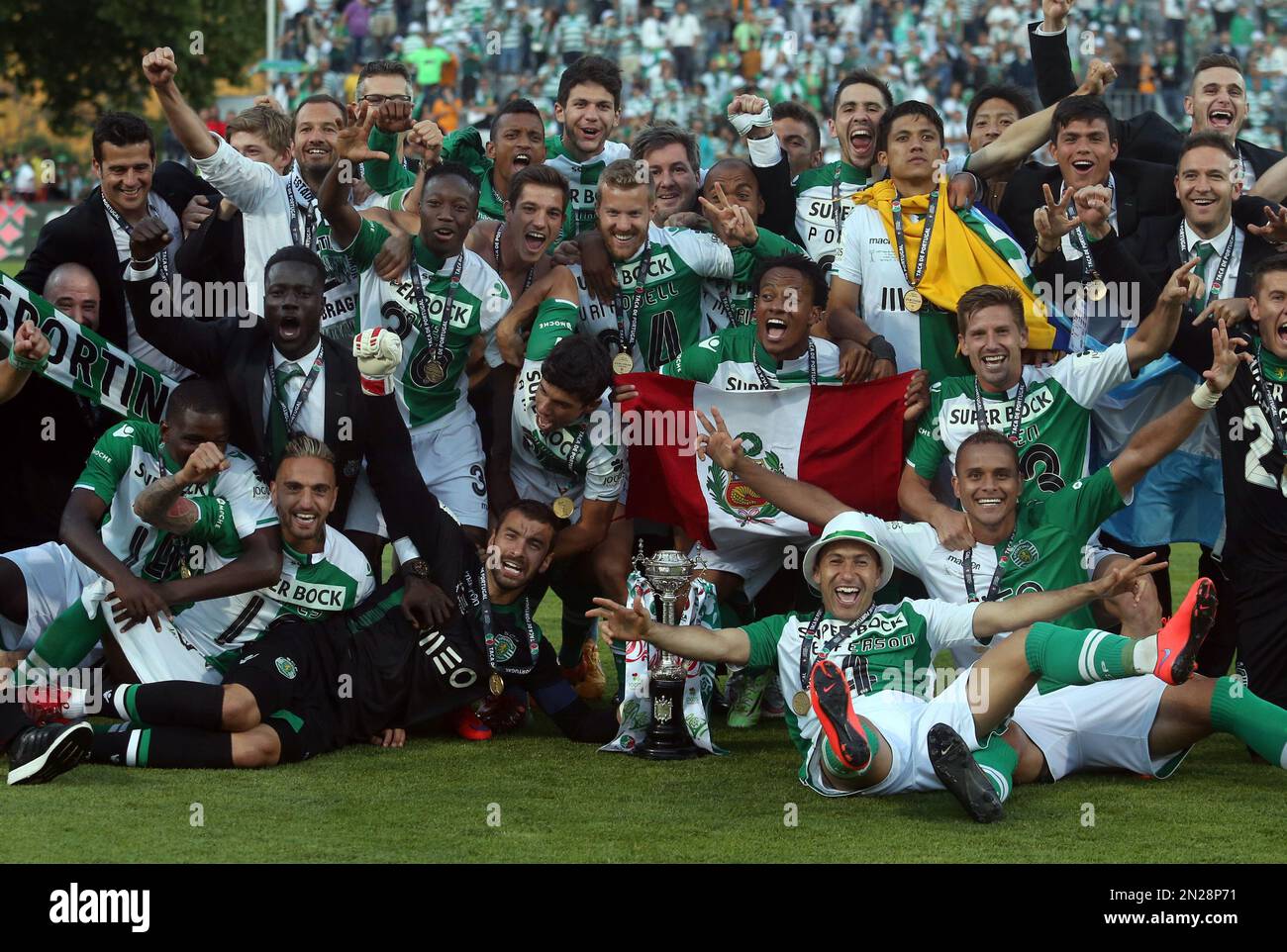 Sporting's players pose for the media with their trophy after winning