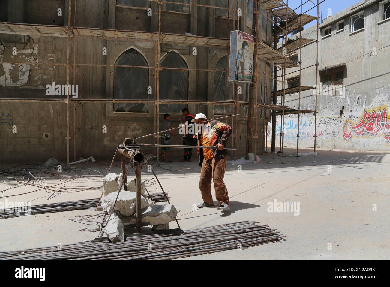 A Palestinian man recycle rebar that was removed from the rubble of