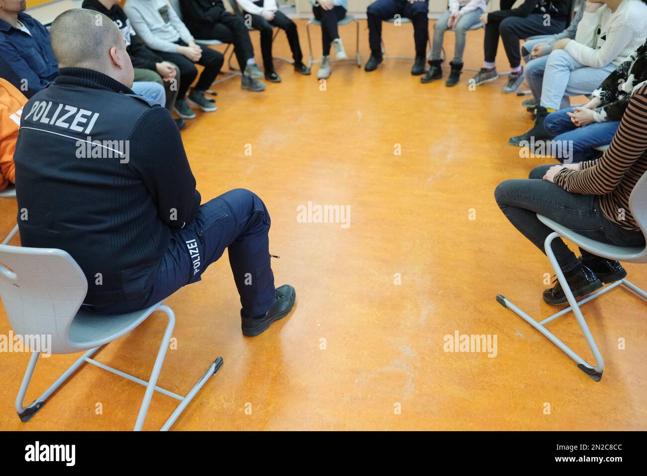 Leipzig, Germany. 06th Feb, 2023. A police officer sits with students at an elementary school. To mark the international 'Safer Internet Day,' prevention officers are educating children about the dangers of using digital media. Credit: Sebastian Willnow/dpa/Alamy Live News Stock Photo