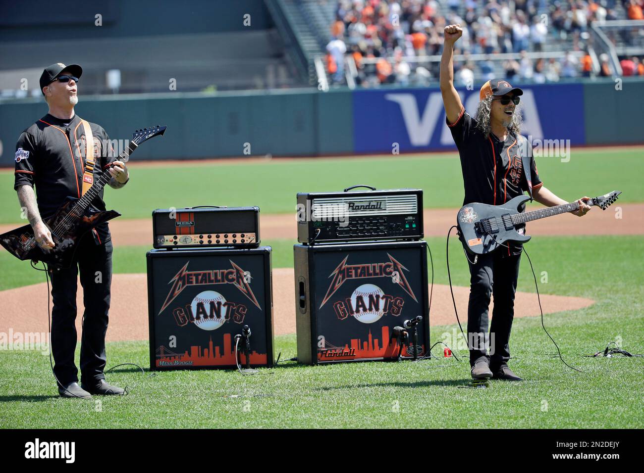 Metallica lead singer James Hetfield, left, salutes the crowd alongside  guitarist Kirk Hammett after playing he national anthem before a baseball  game between the San Francisco Giants and Los Angeles Angels on