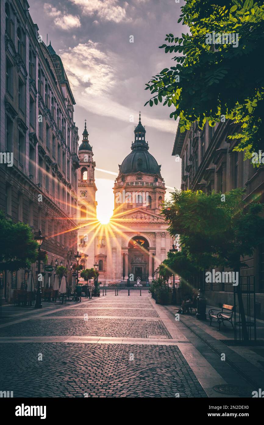 Street view of St. Stephen's Basilica, city view with sun star and sunrise, church, cathedral, Budapest, Hungary Stock Photo