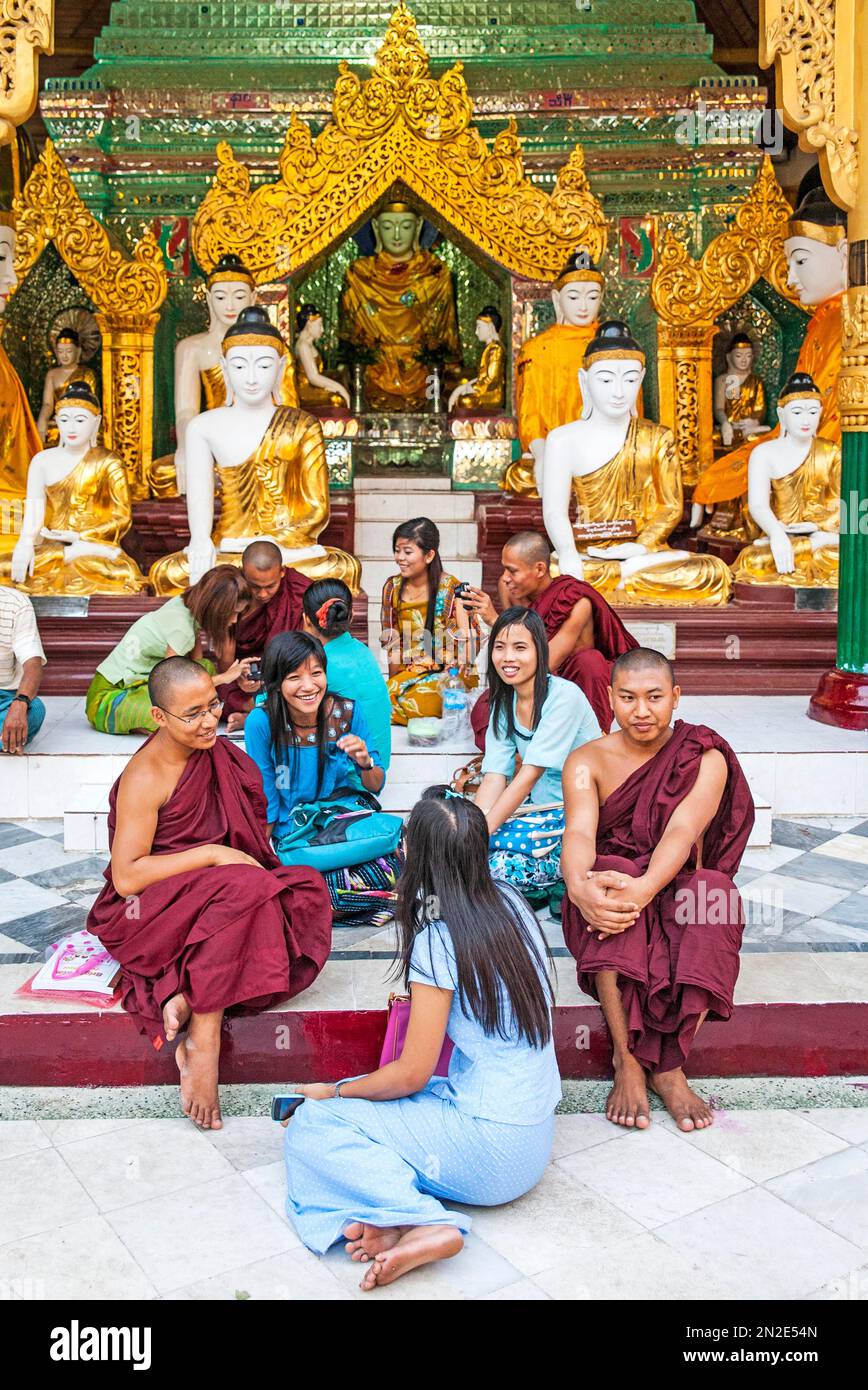 Resting in front of Buddha statues in shrine, Shwedagon Pagoda, Yangoon, Myanmar, Yangoon, Myanmar, Asia Stock Photo