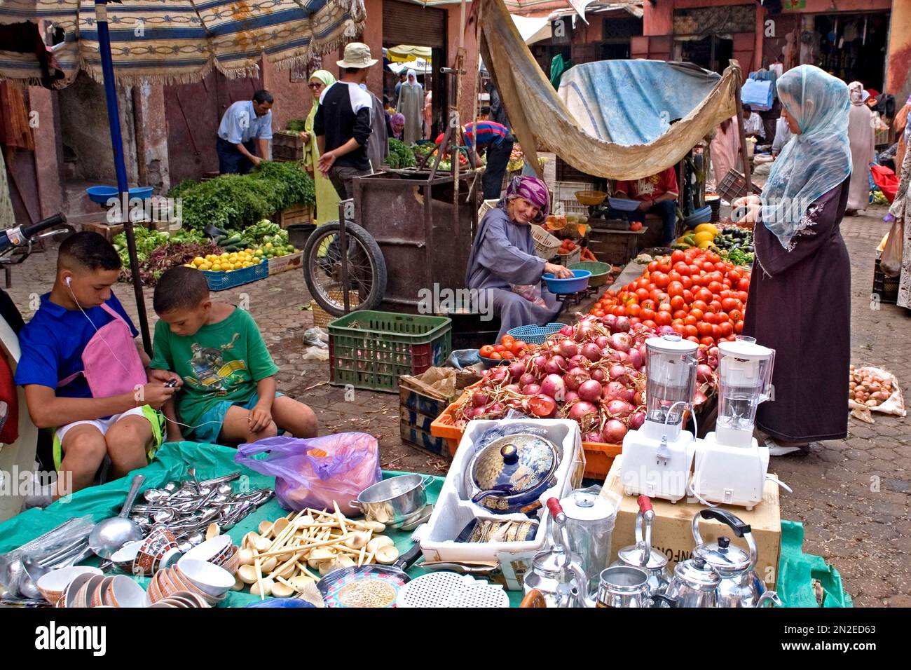 Children with mobile phones and vendors in the souk, Marrakech, Morocco, Africa Stock Photo