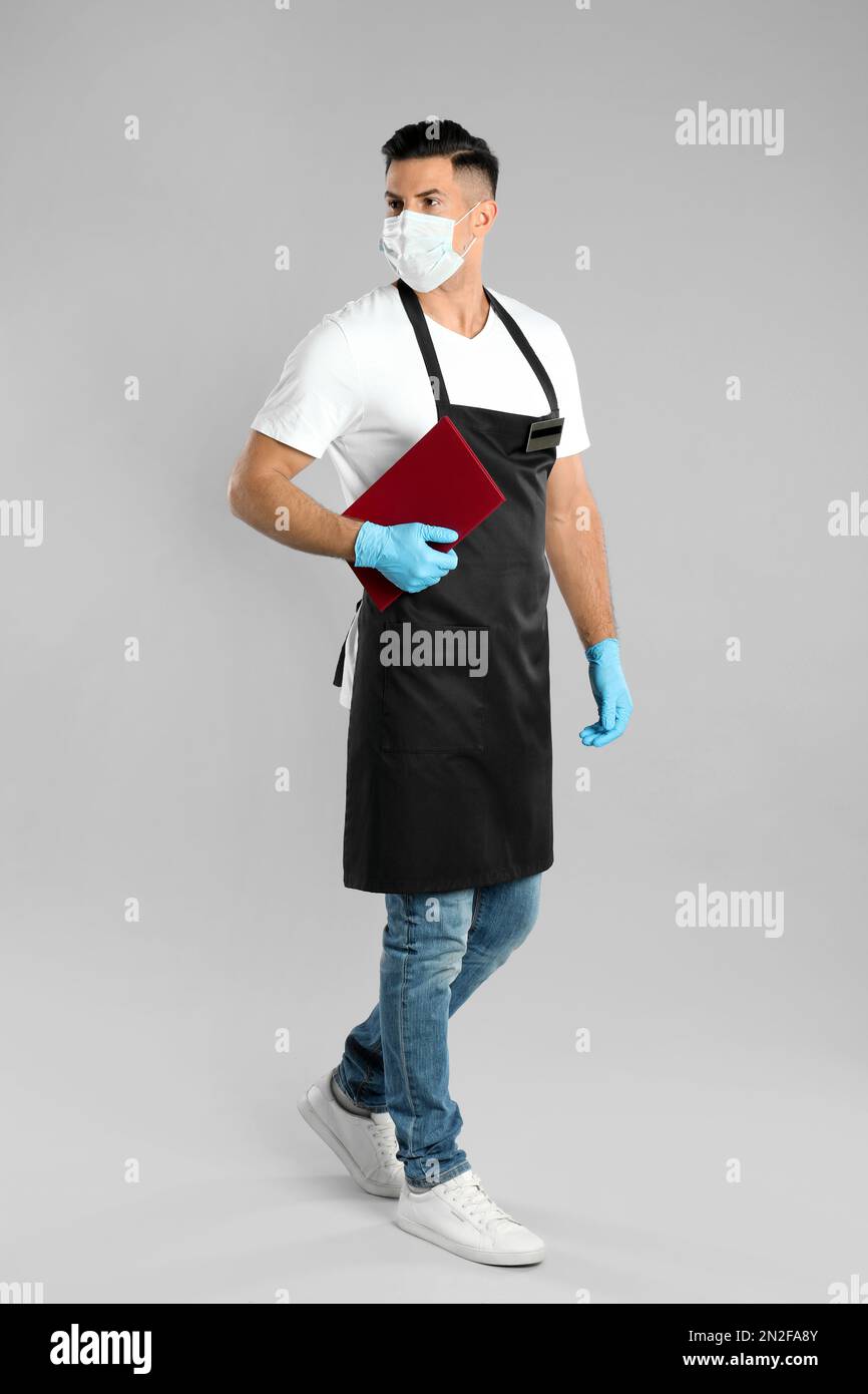 Waiter in medical face mask with menu on light grey background Stock ...