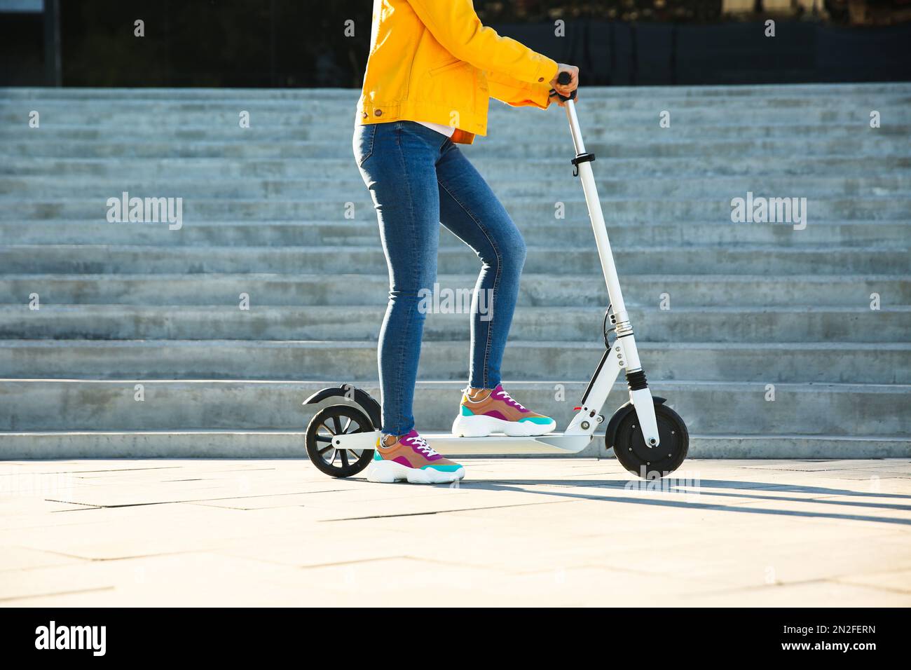 Woman riding on kick scooter hi-res stock photography and images - Alamy