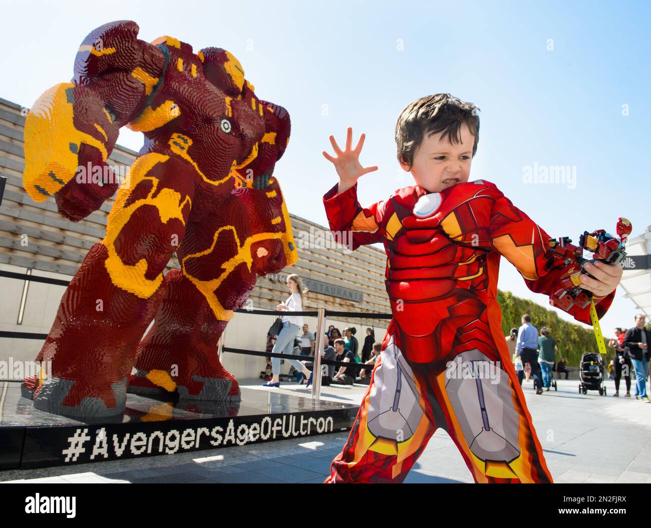 IMAGE DISTRIBUTED FOR LEGO Alfie Ward dressed as Little Iron Man poses in front of the UK s largest LEGO statue as it is unveiled at the London premiere of LEGO Super