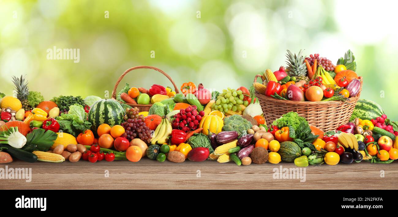 Assortment of fresh organic vegetables and fruits on wooden table ...