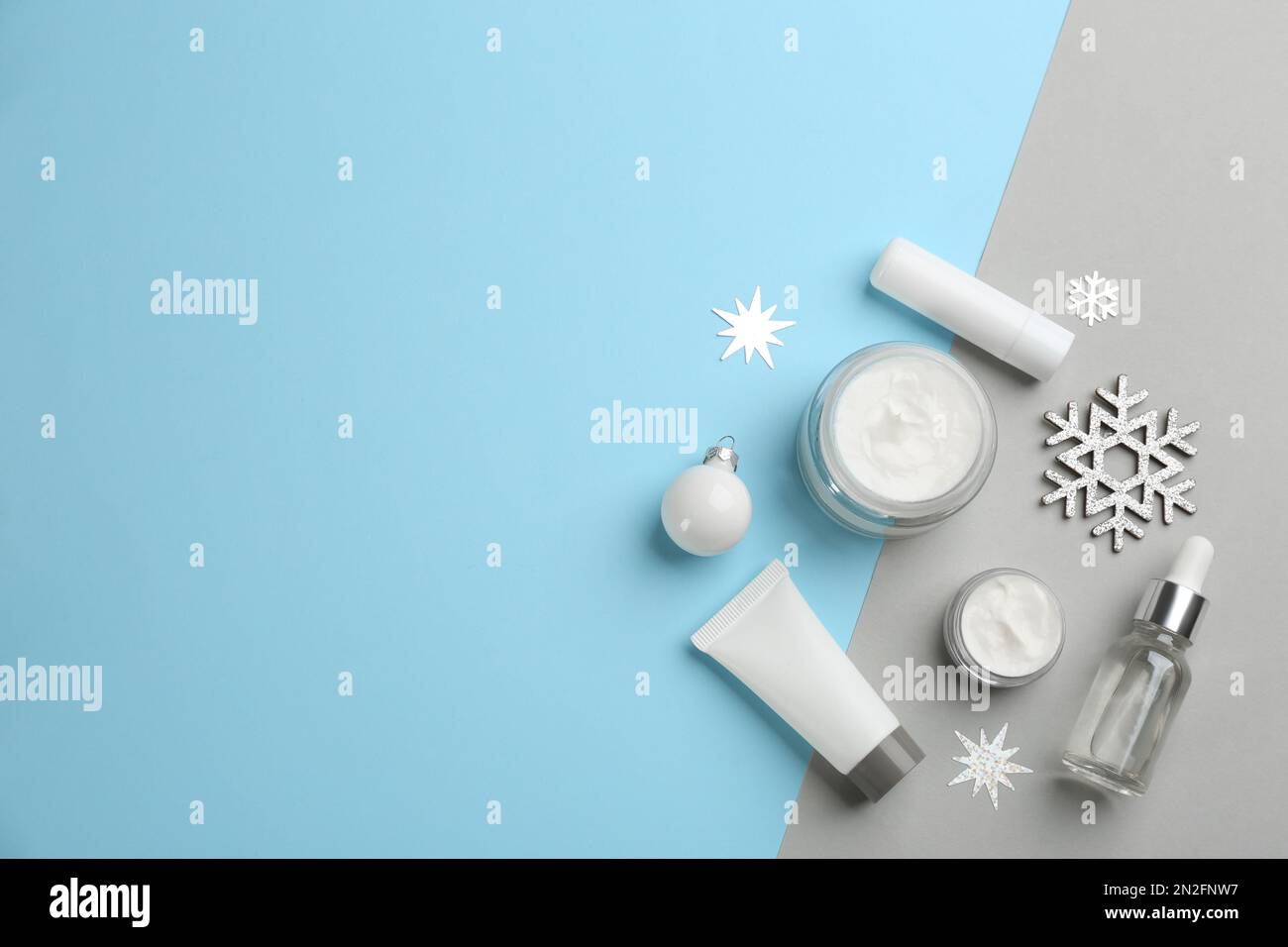 Flat lay composition with cosmetic products on light blue and grey ...
