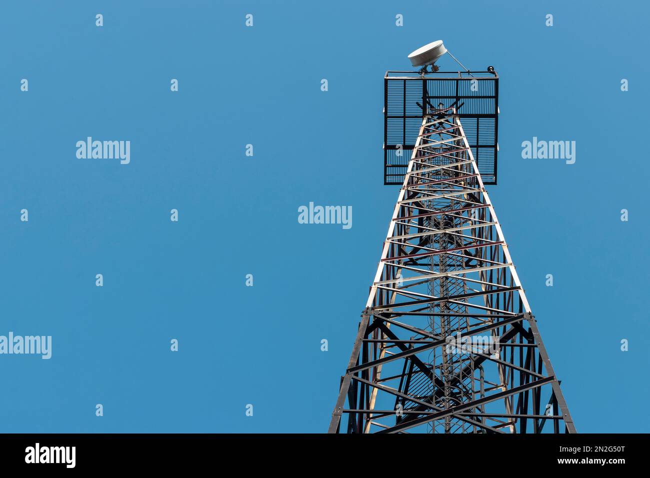 Radio relay antenna on a metal tower. Against the background of the blue sky. Stock Photo