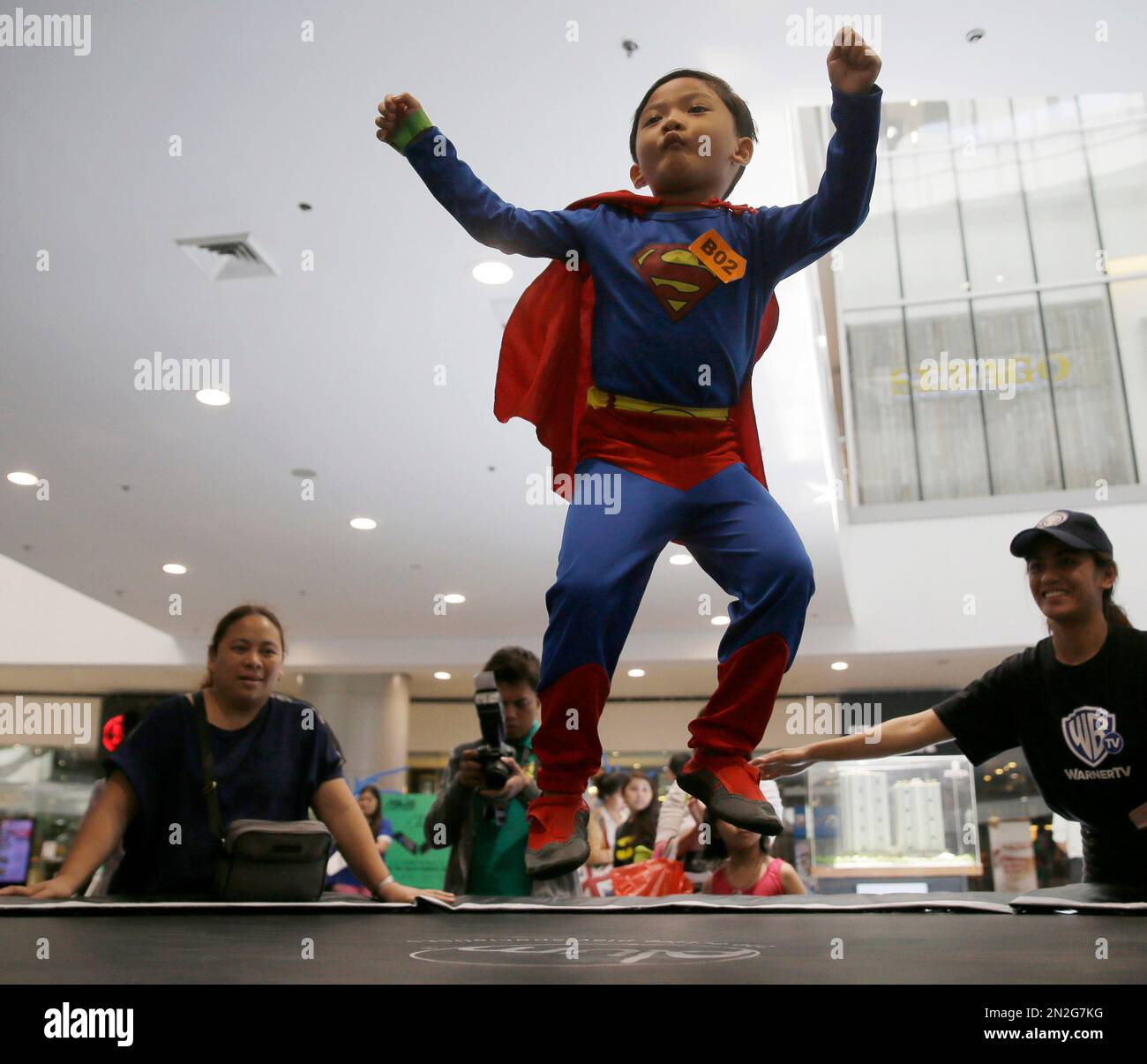 A boy, dressed as Superman, jumps on the trampoline as Filipino fans of DC  comics super heroes gather at the country's largest shopping mall during an  attempt to establish a world record