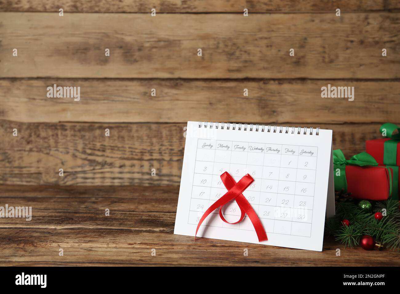 Calendar with marked Boxing Day date and gifts on wooden table. Space