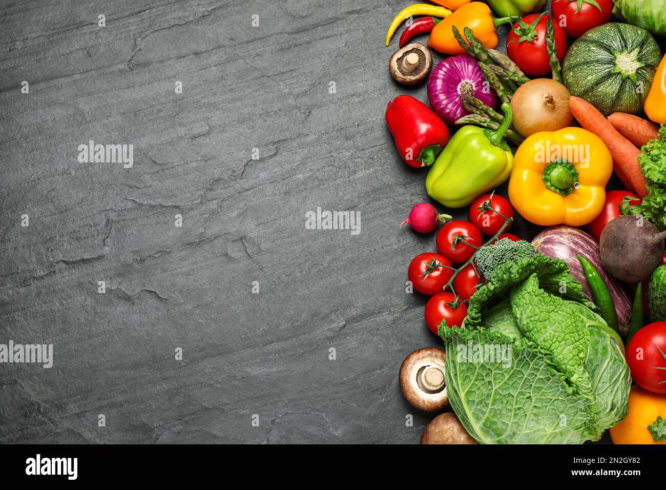 Flat lay composition with fresh vegetables on black table. Space for ...
