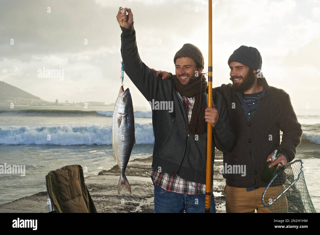 Im smiling, but that fish shouldve been mine...two young men fishing off a pier. Stock Photo