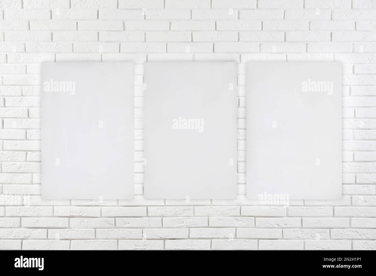 Blank poster on white brick wall. Mockup for design Stock Photo Alamy