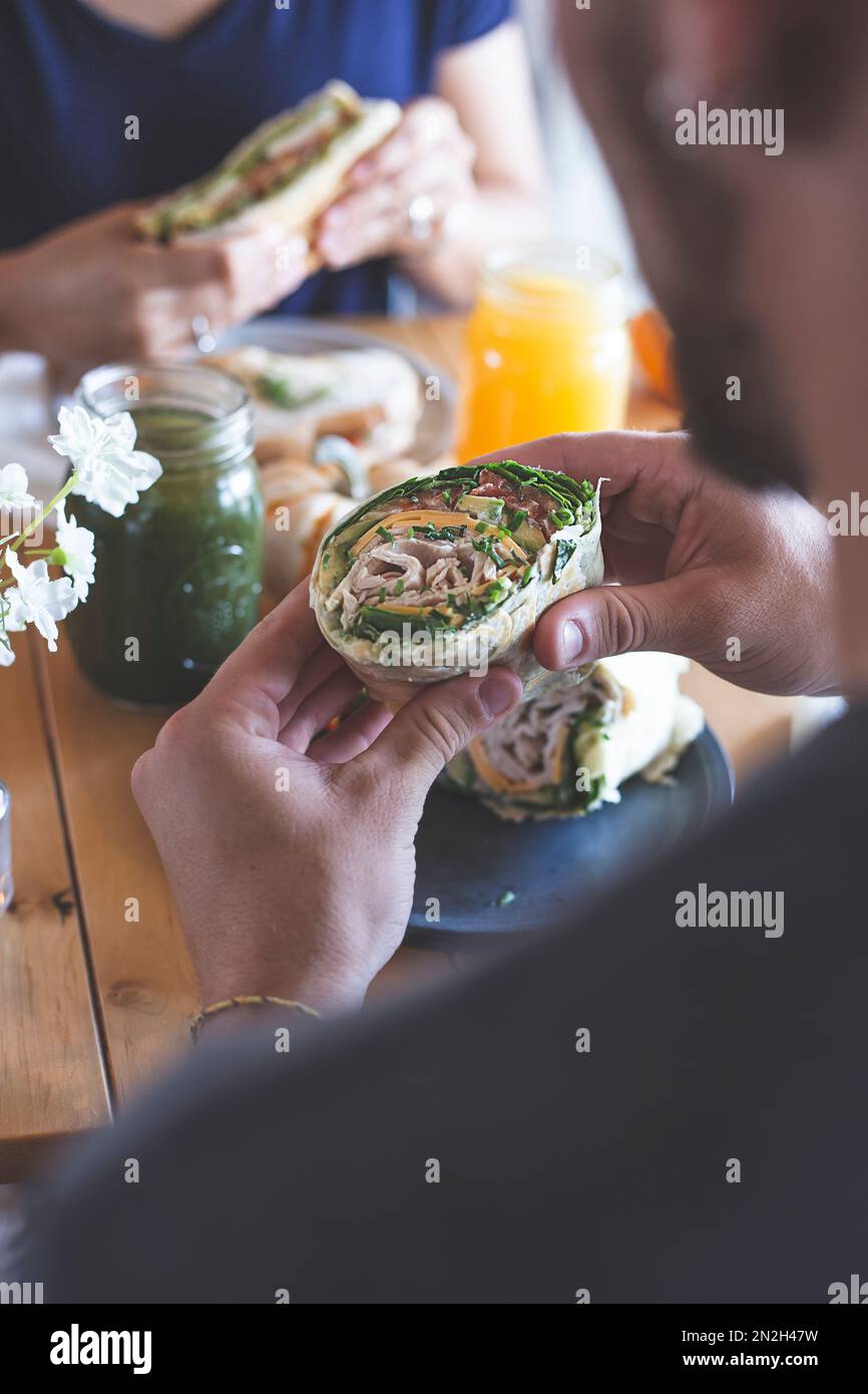 Male and female couple eating in a restaurant. Wrap and sandwich with natural juices. Healthy