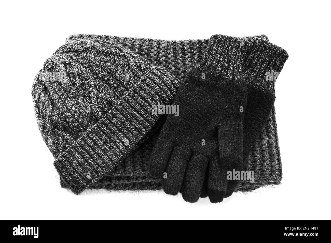 Black woolen gloves, scarf and hat on white background, top view. Winter clothes Stock Photo