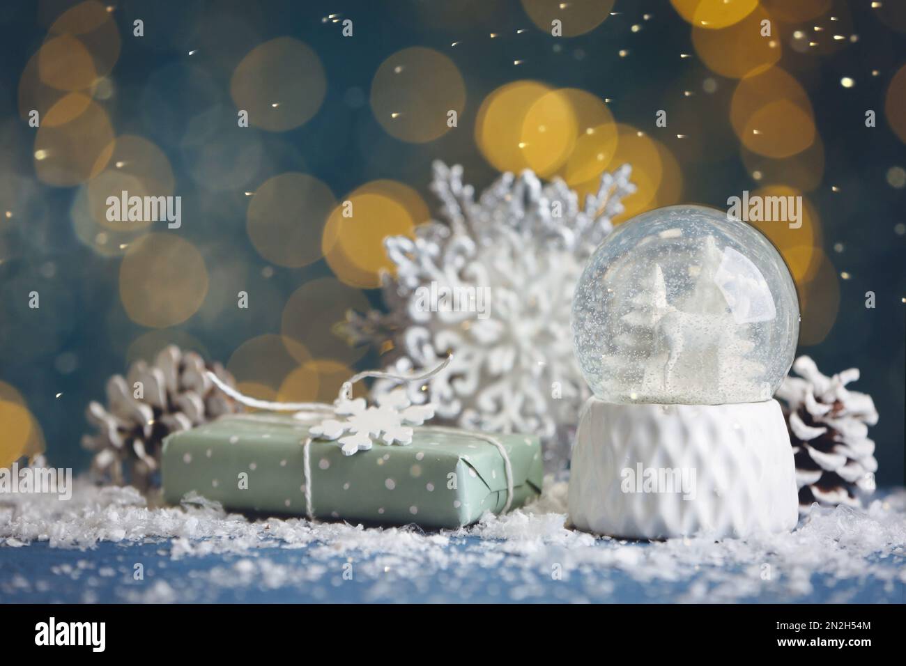 Beautiful snow globe, gift and decor on blue table against blurred Christmas  lights Stock Photo - Alamy, image size:1300x956