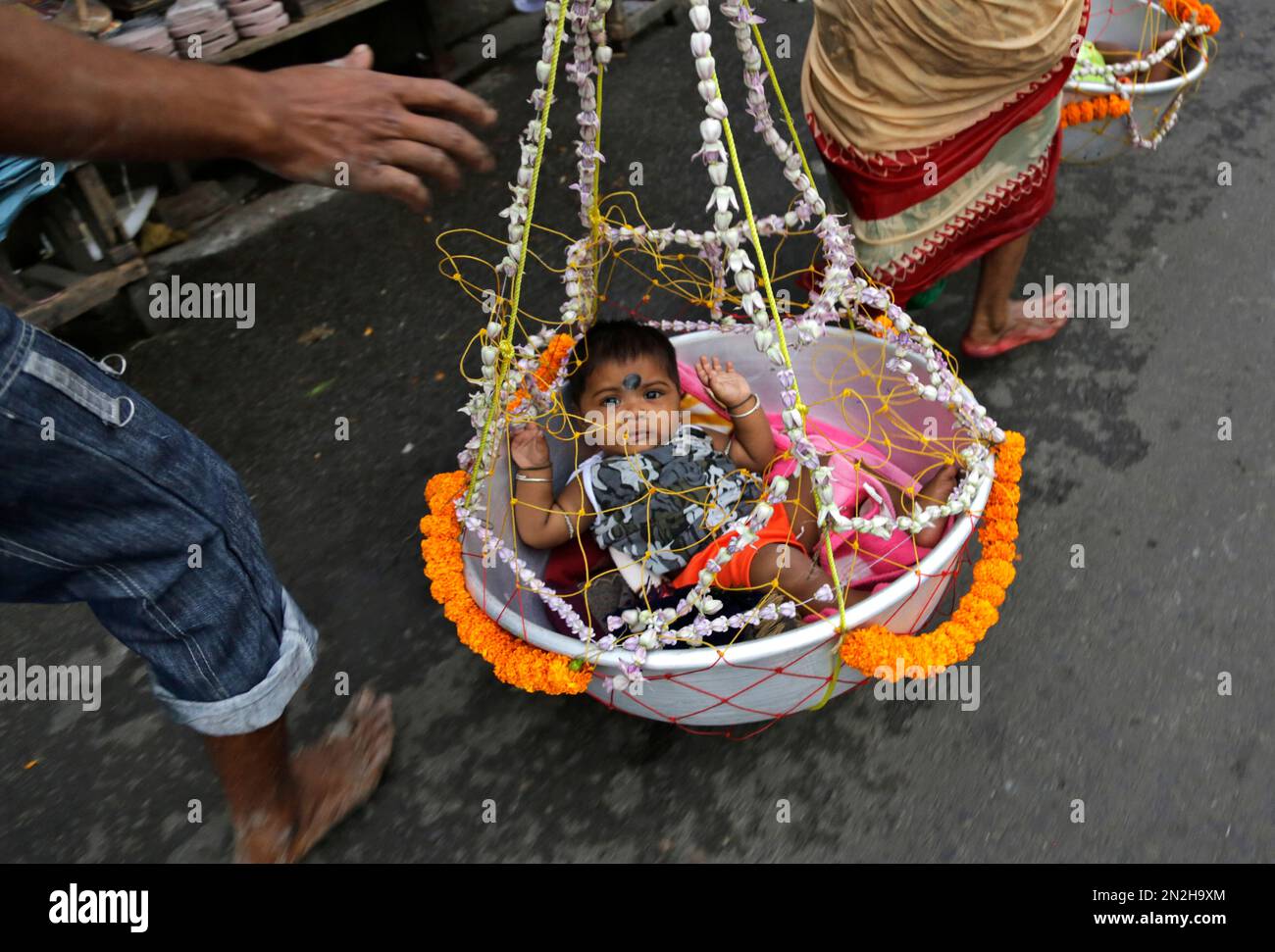 A Hindu devotee walks towards a Hindu god Shiva temple carrying her two ...