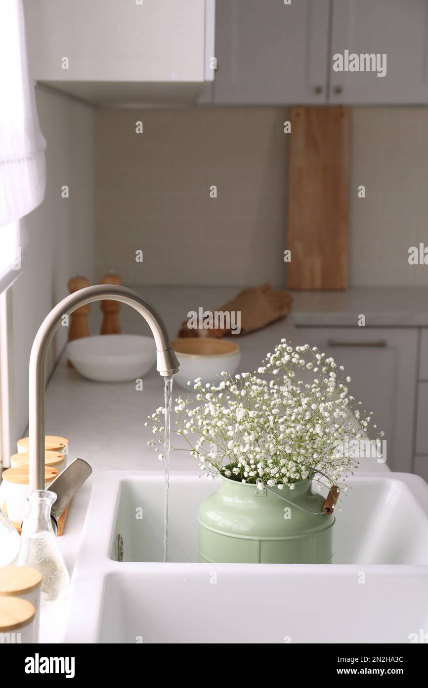 Bouquet of gypsophila flowers in sink. Kitchen interior design Stock