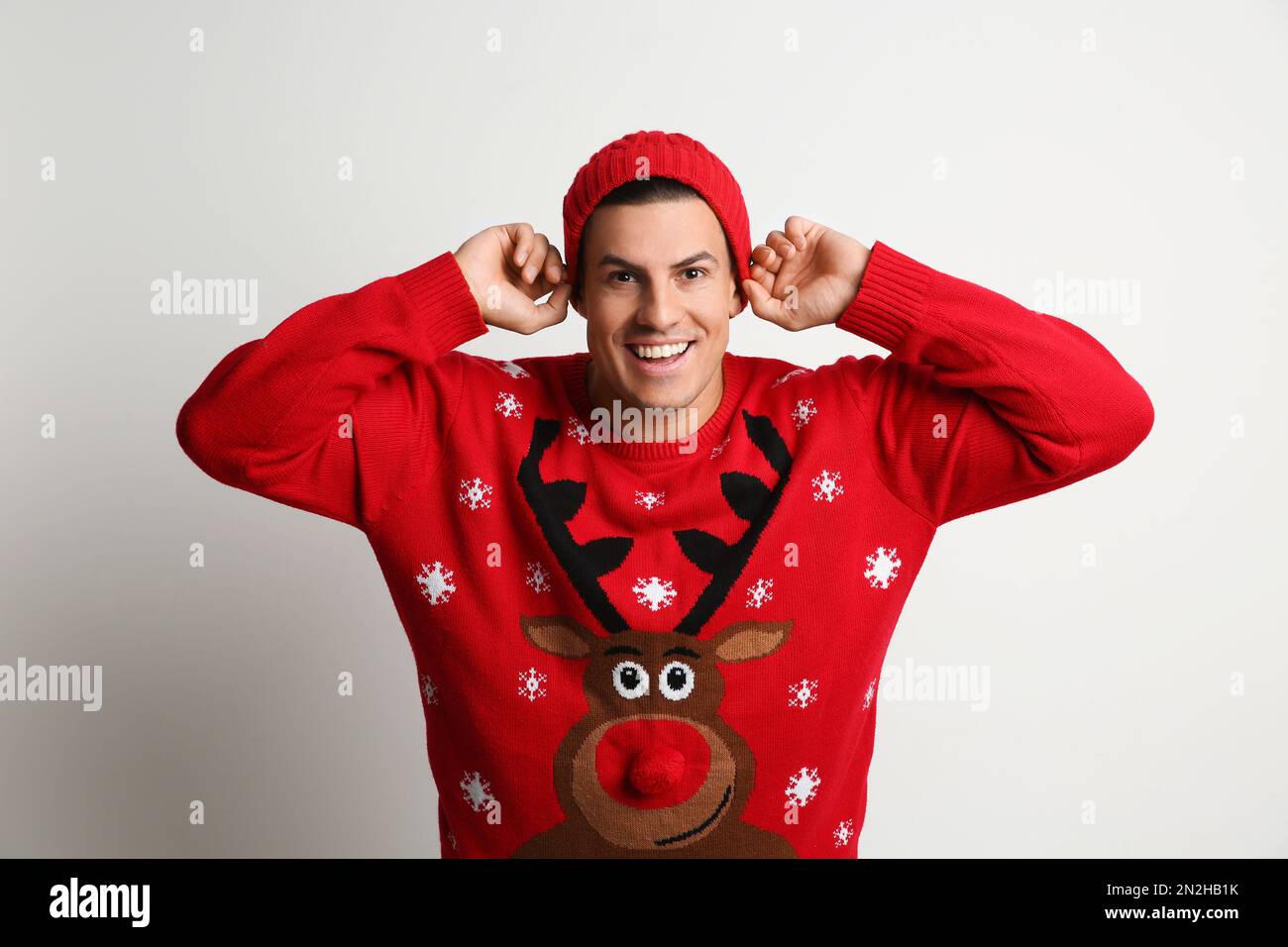Happy man in Christmas sweater and hat on white background Stock Photo ...
