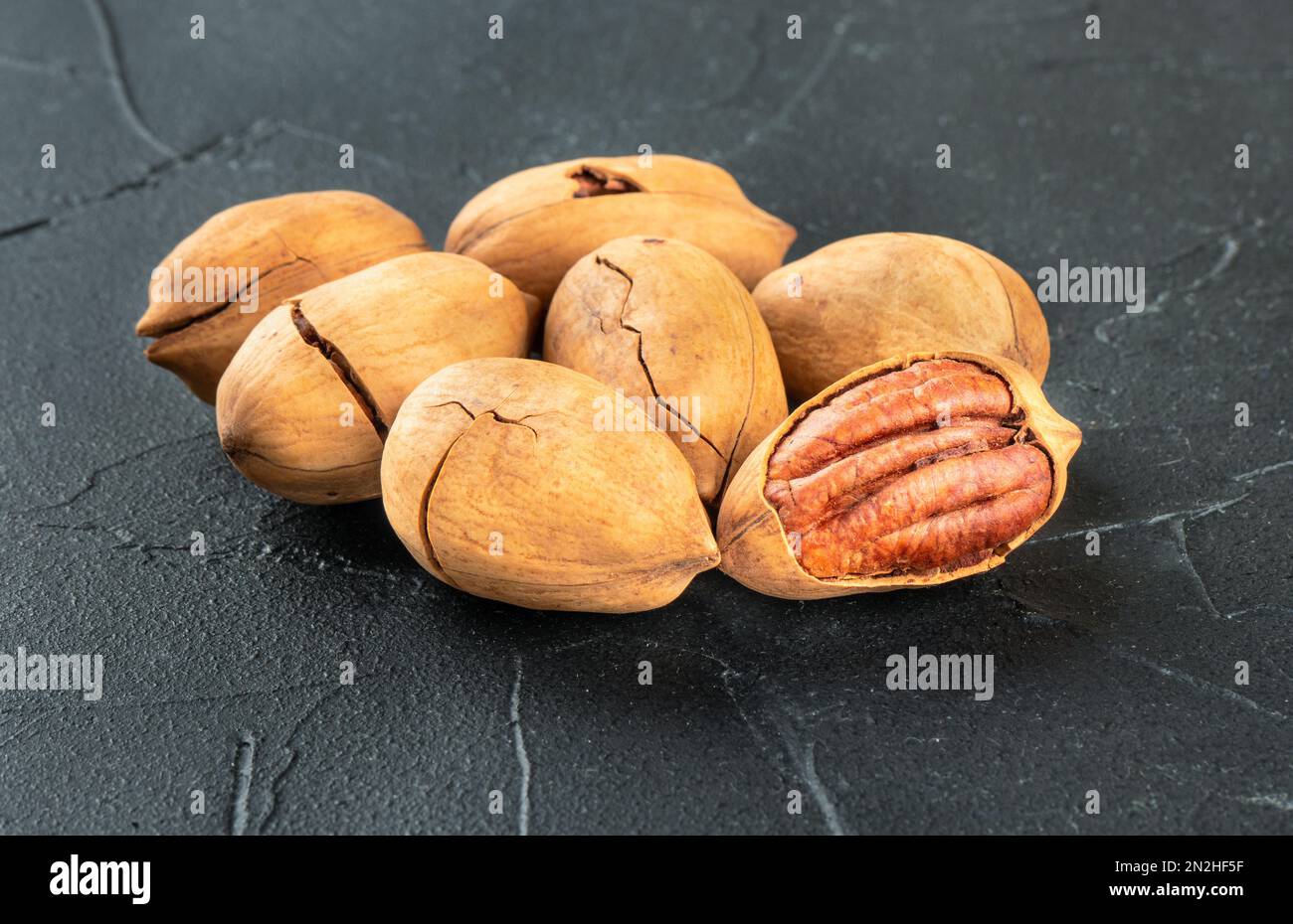 Small pile of inshell pecans close up on a dark background Stock Photo