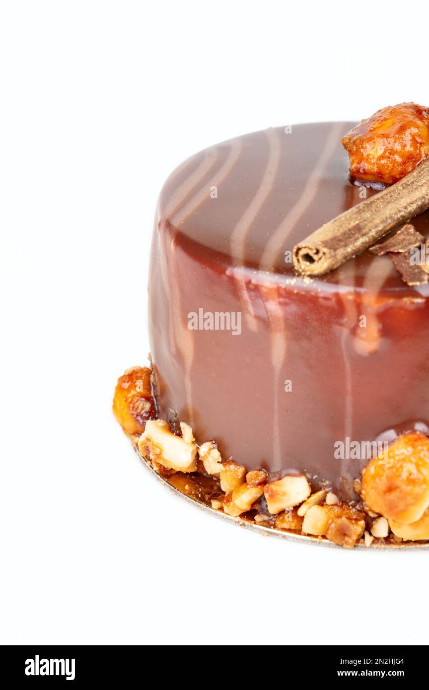 Piece of chocolate brownie with salted caramel and cookies inside. Decorated with nuts around the edges. Stock Photo
