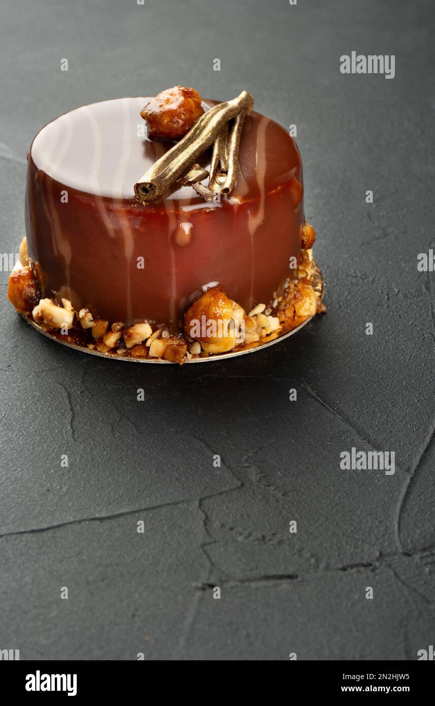 Beautiful chocolate brownie with mascarpone and salted caramel on a dark concrete background