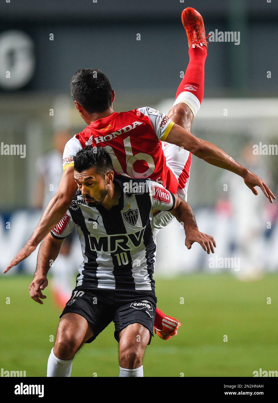 CORRECTING SANTA FE'S COUNTRY TO COLOMBIA - Datolo of Brazil's Atletico Mineiro, bottom, fights for the ball with Daniel Torres of Colombia's Santa Fe, during a Copa Libertadores soccer game in Belo Horizonte, Brazil, Thursday, April 9, 2015. (AP Photo/Juliana Flister) Stock Photo