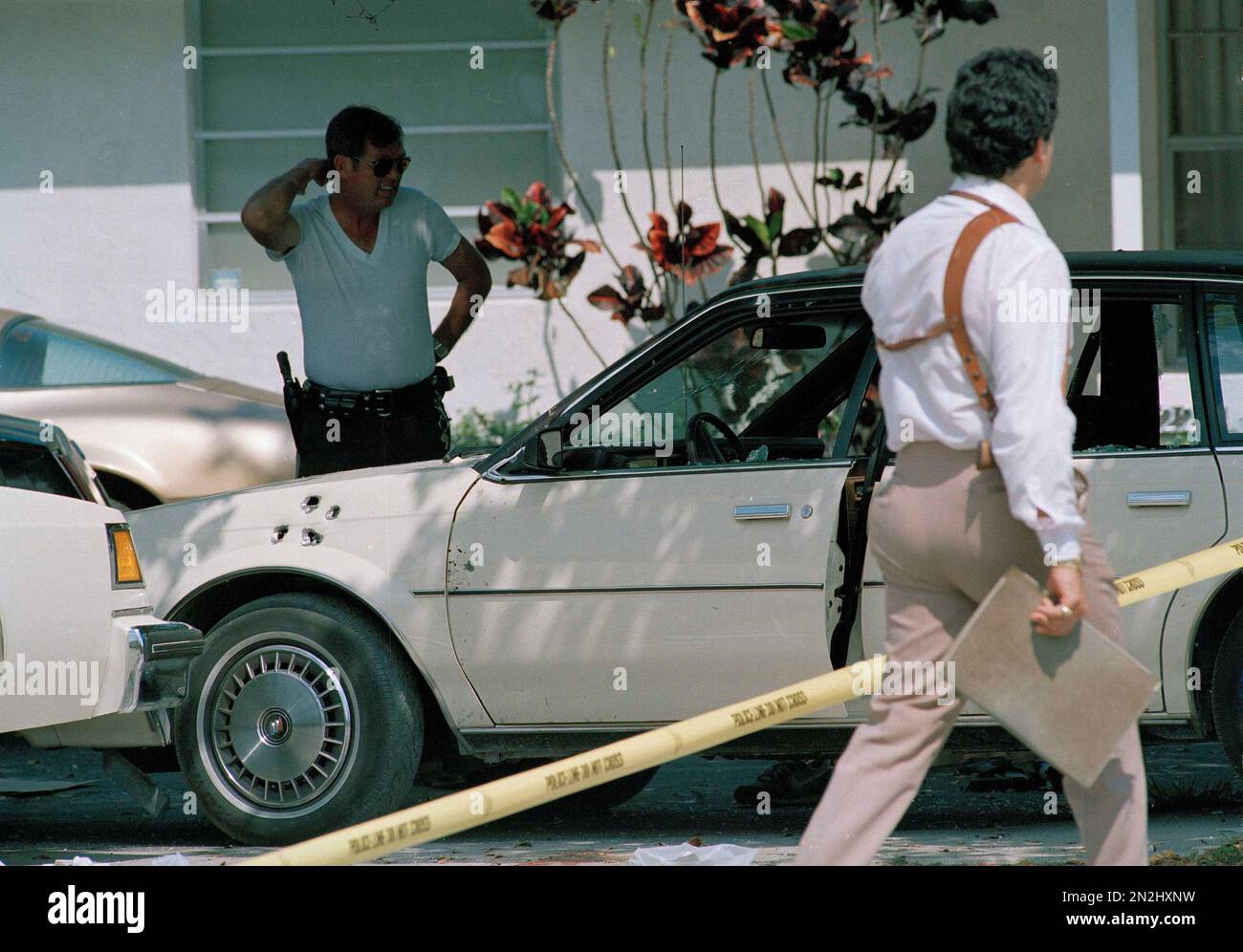 Law enforcement officials survey the scene of a shootout in which two ...