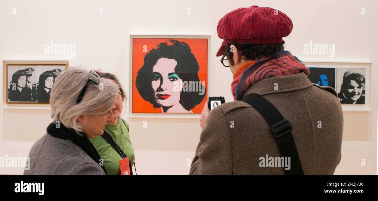 Visitors take photographs of the painting 