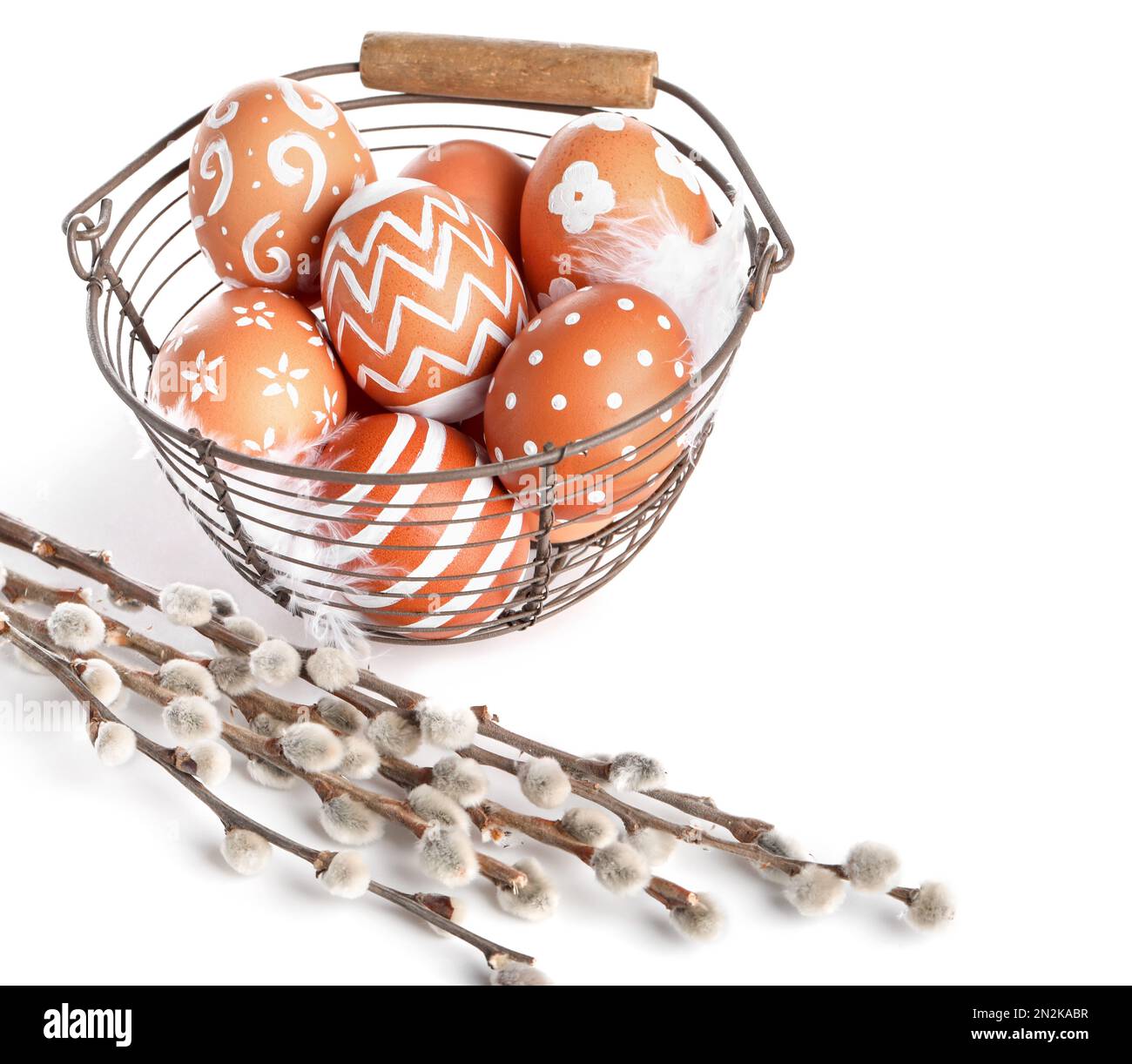Basket with painted Easter eggs and willow branches on white background ...