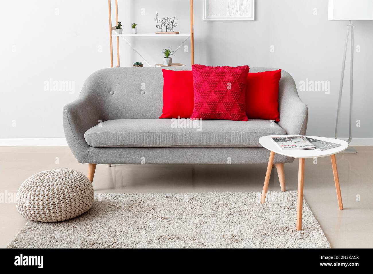 Interior of modern living room with red pillows on grey sofa Stock Photo Alamy