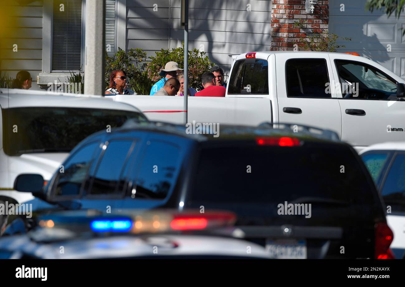 An off-duty Los Angeles police officer, in red, talks to investigators ...