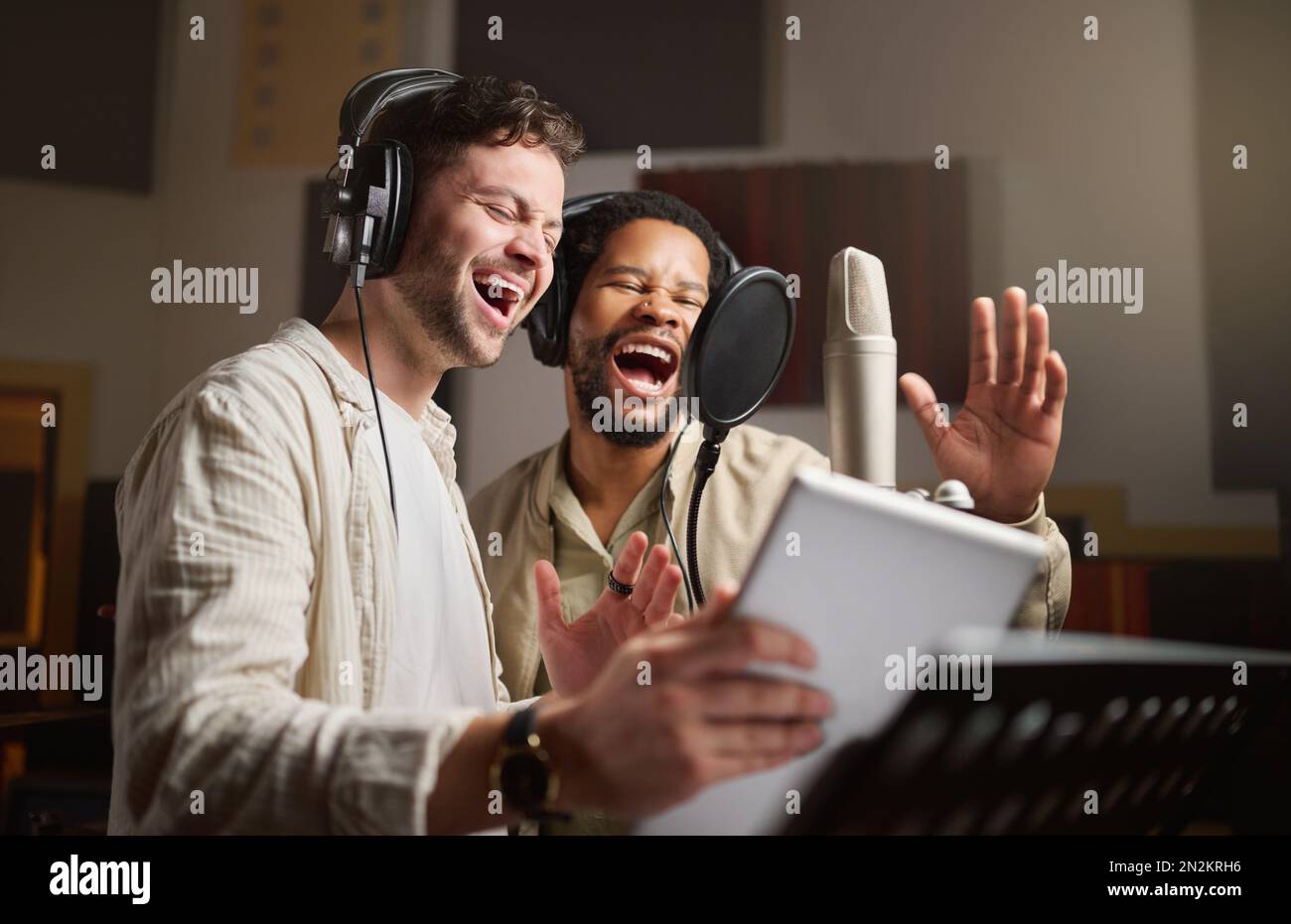 Music, singing and men recording in studio tablet, streaming with microphone, headphones and talent. Technology, art and creative influencer band and Stock Photo