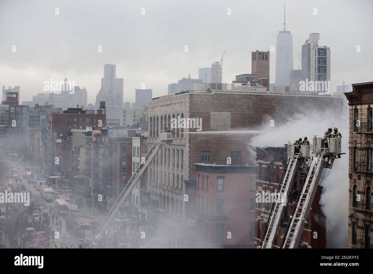 New York City firefighters work the scene of a large fire and a partial ...