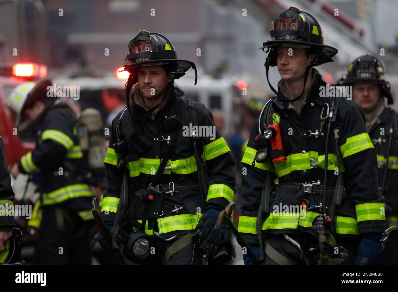 New York City firefighters work at the scene of a large fire and a ...