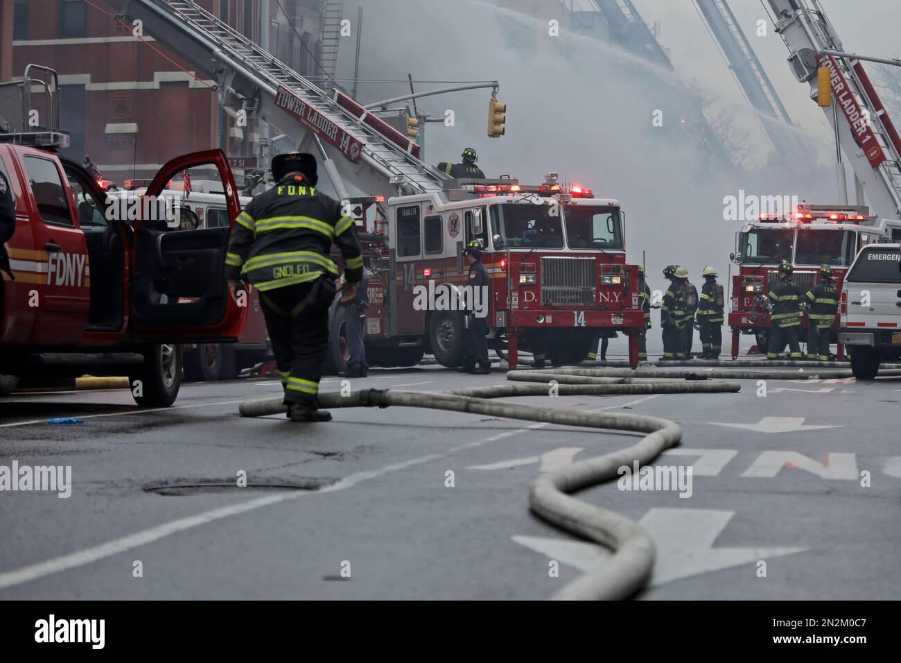 New York City firefighters work at the scene of a large fire and a ...