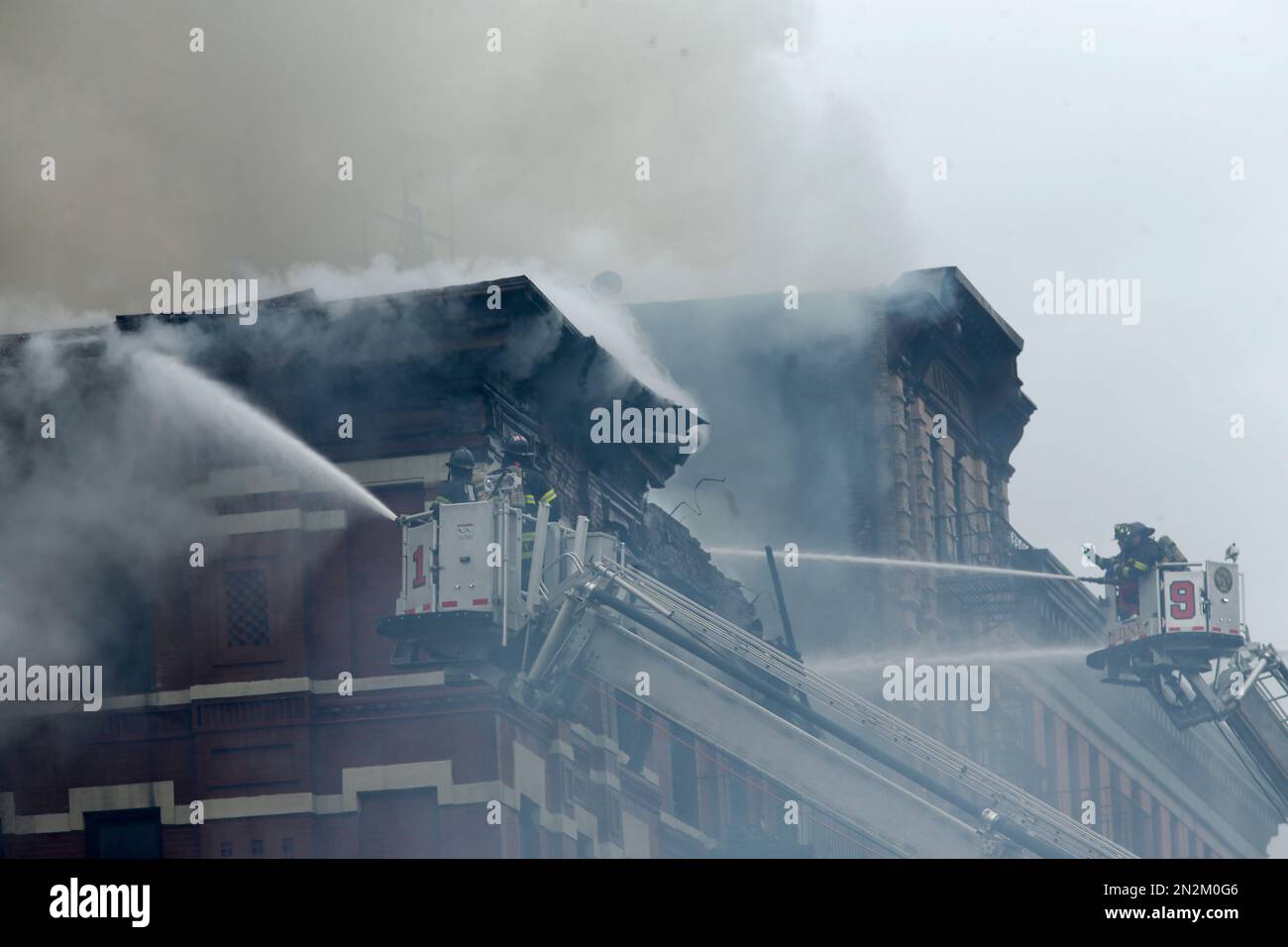 New York City firefighters work at the scene of a large fire and a ...