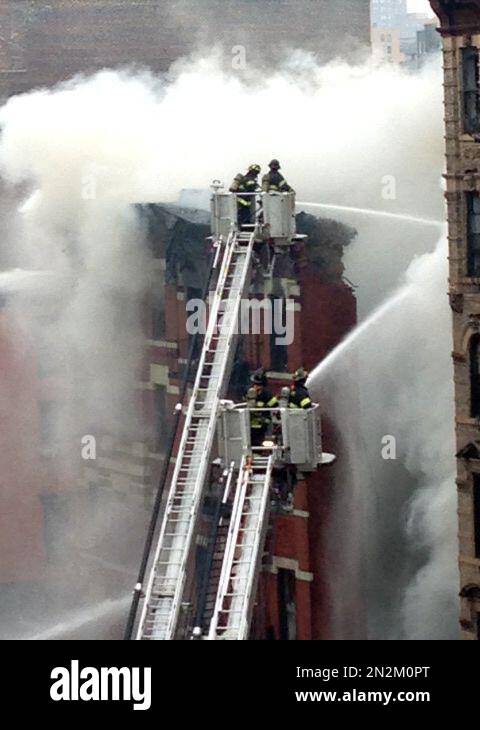 New York City firefighters spray water at scene of a large fire and ...