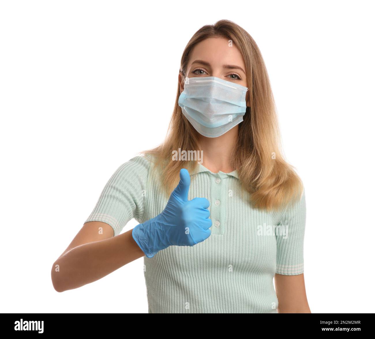 Young woman in medical gloves and protective mask showing thumb up on ...
