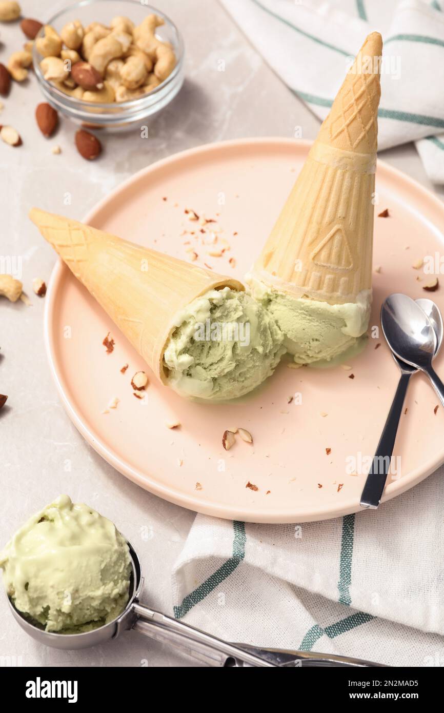Delicious pistachio ice cream in wafer cones with chopped nuts served