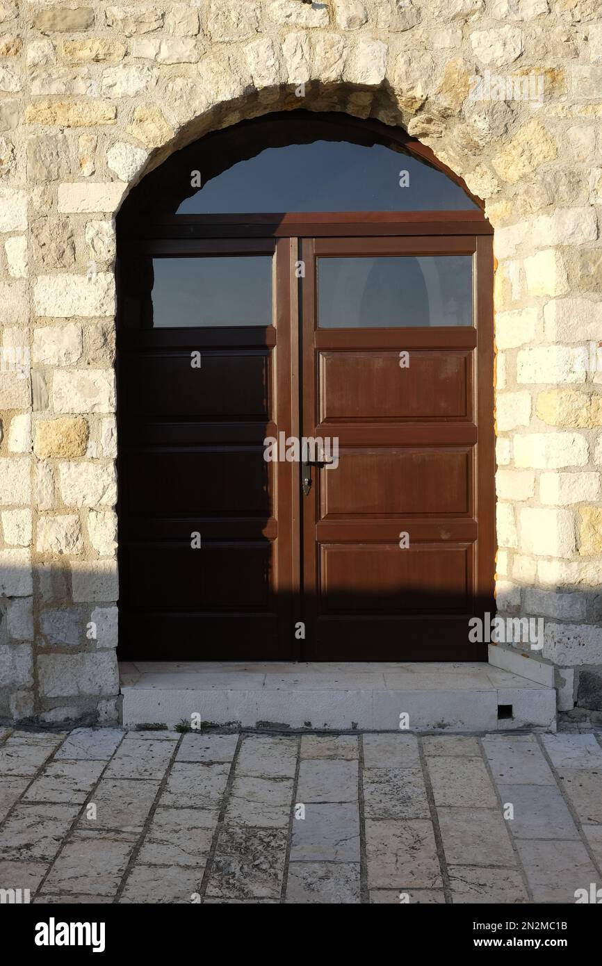Old wooden door in the stone wall of the monastery Stock Photo - Alamy