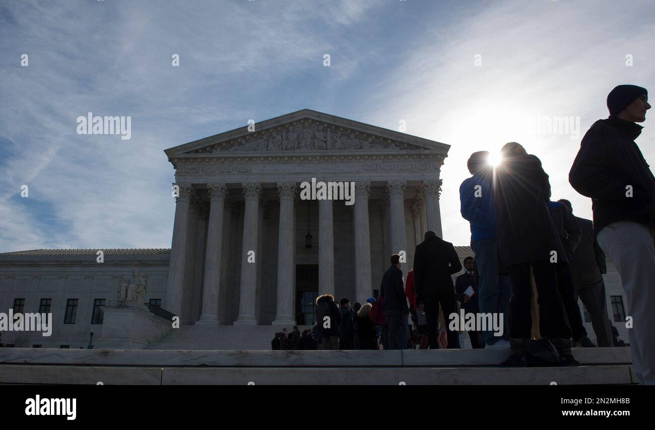People wait in line outside the Supreme Court in Washington, Monday, March 23, 2015, in hopes to gain admittance for oral arguments. (AP Photo/Molly Riley) Stock Photo