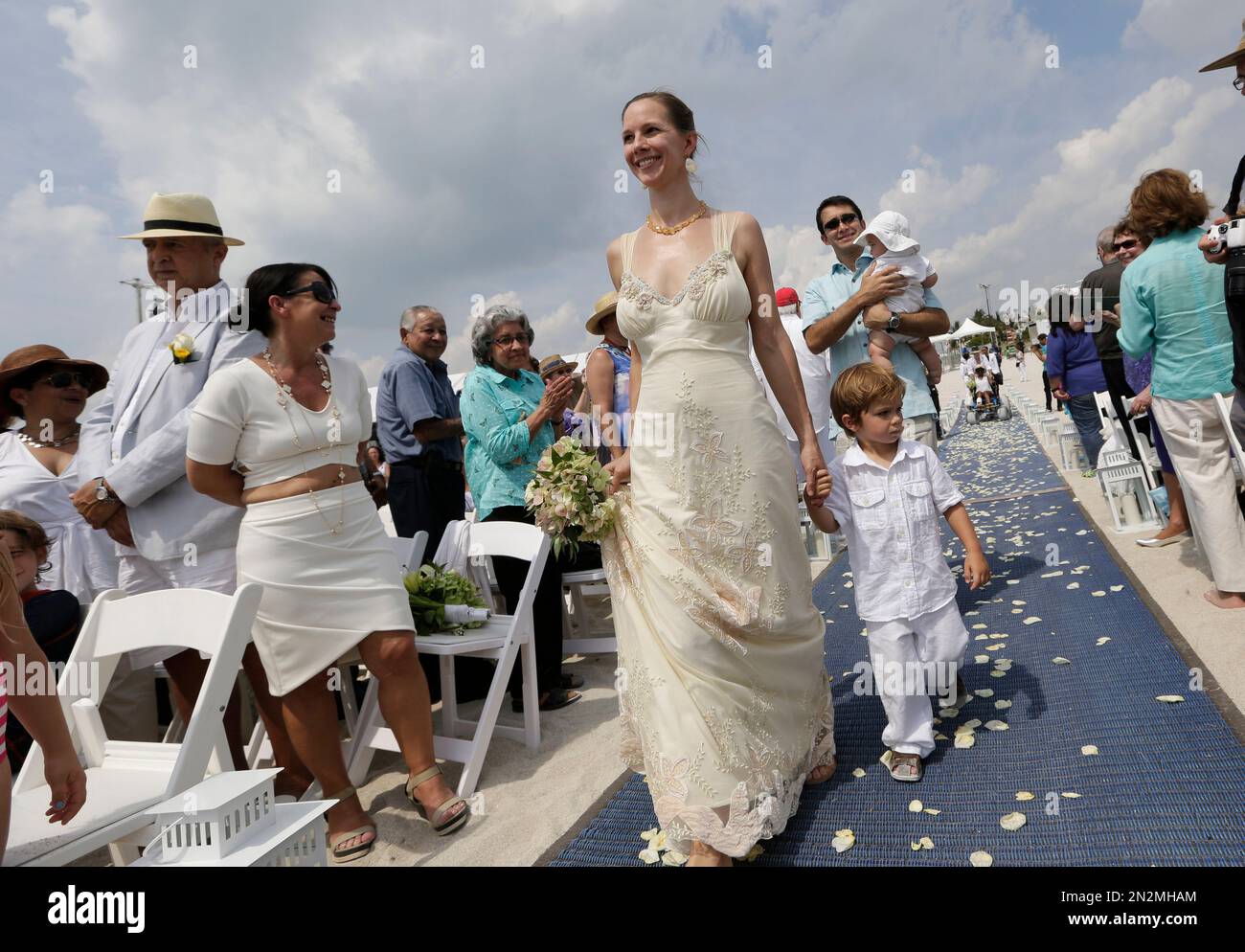 Elizabeth Maples, center, walks with her son Lincoln down the aisle