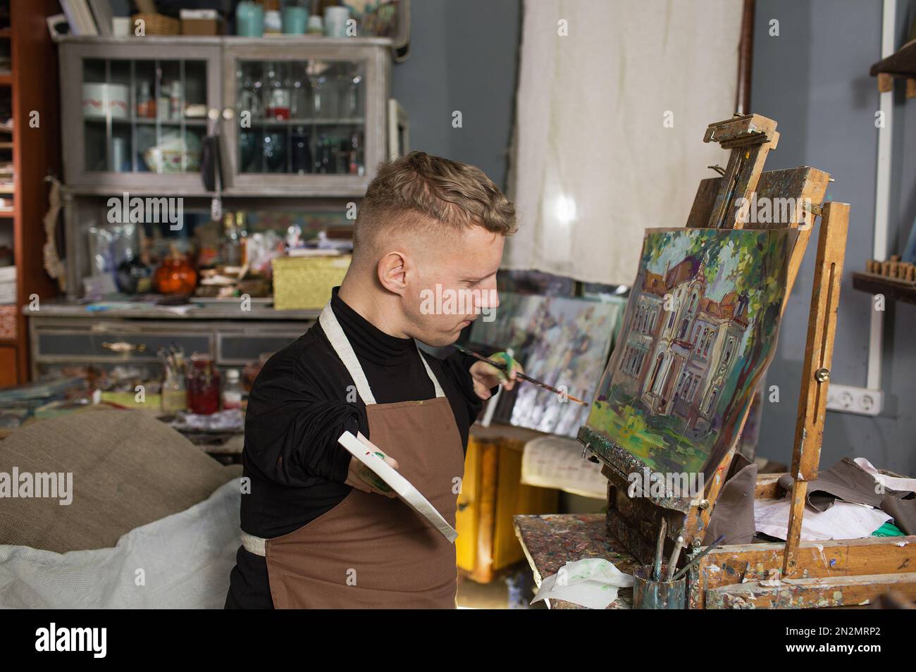a man with disabilities draws pictures and is engaged in art. Stock Photo