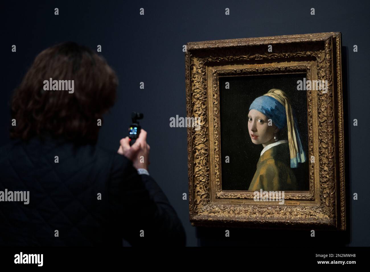 A journalist takes images of Girl with a Pearl Earring during a press